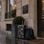 Hôtel de Naples à Vichy : façade et entrée près de la gare, valise sur trottoir mouillé